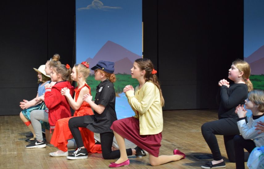 Children performing Honk Jr. on stage in costume all kneeling